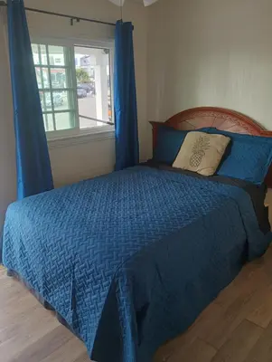 a bedroom with a bed with a blue comforter and a window at Oceana Boutique Hotel in San Clemente