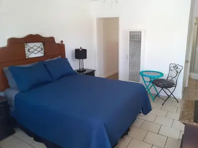 a bedroom with a blue bed and a chair at Oceana Boutique Hotel in San Clemente