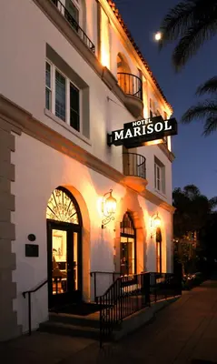 a white building with a sign on the side of it at Hotel Marisol Coronado in San Diego