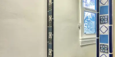 a wall with a window with blue and white tiles at Beachcomber Inn in San Clemente