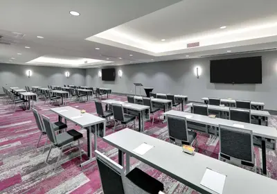 a classroom with tables and chairs and a projection screen at Hampton Inn by Hilton Irvine Spectrum Lake Forest in Lake Forest