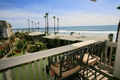 a balcony with two chairs and a view of the beach at E210 - Starfish Studio in Oceanside