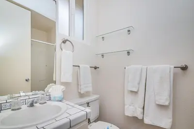 a white bathroom with a sink and a mirror at G218 - Palms Away in Oceanside