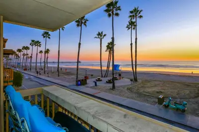 a view of the beach and palm trees at sunset at A22 - Oceanfront Dream in Oceanside