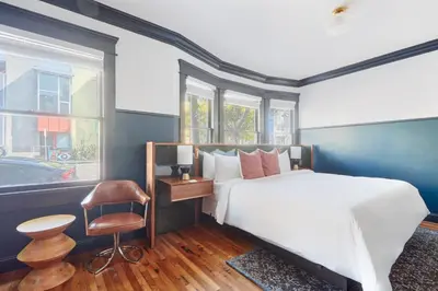 a bedroom with a bed and a chair and windows at The Davis Downtown San Diego in San Diego