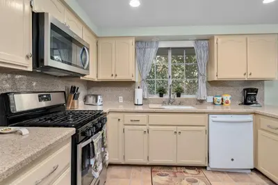 a kitchen with white cabinets and a stove top oven at The Heart of Julian in Julian