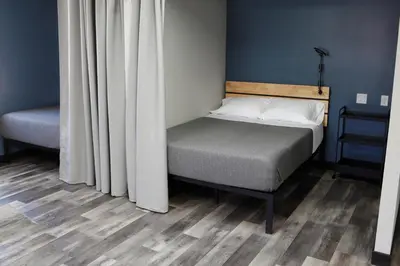 a small bedroom with a bed and a curtain at Stay Classy in San Diego