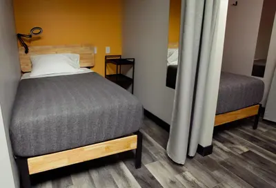 a small bedroom with a bed and a mirror at Stay Classy in San Diego