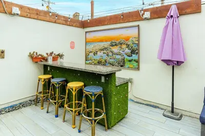 a bar with stools and a purple umbrella at Samesun Ocean Beach Hotel & Hostel in San Diego