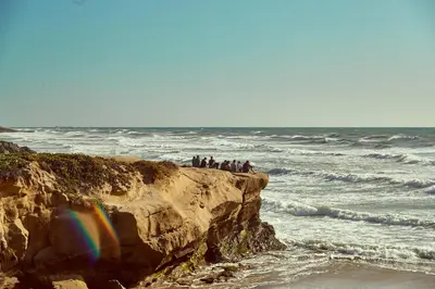 a group of people standing on a cliff near the ocean at Samesun Ocean Beach Hotel & Hostel in San Diego