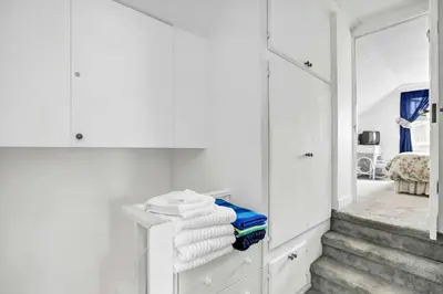 a room with white cabinets and stairs with towels at 201 Amethyst Avenue in Newport Beach