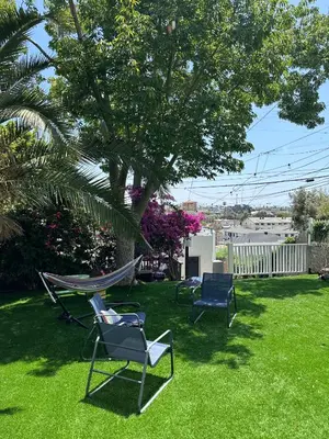 a yard with chairs and a hammock under a tree at Casita San Diego in San Diego