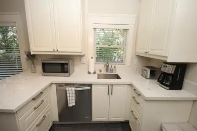 a kitchen with white cabinets and a sink and a microwave at Fern House South Park Craftsman in San Diego