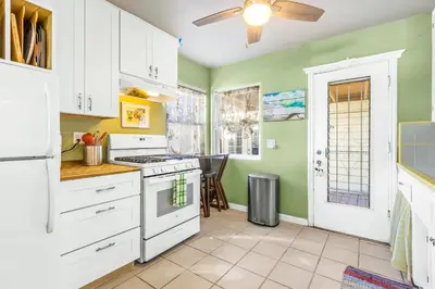 a kitchen with white appliances and green walls at Pacific Sunrise in San Diego