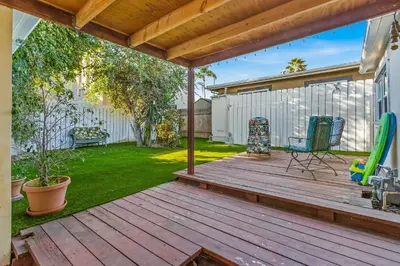 a backyard with a wooden deck with two chairs at Pacific Sunrise in San Diego