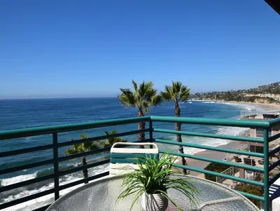 a table and chair on a balcony overlooking the ocean at Laguna Surf in Laguna Beach