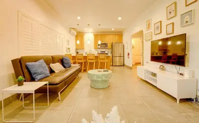 a living room with a brown couch and a kitchen at 1000#1 Contemporary Home w/ Parking, Grill, & AC! in Newport Beach