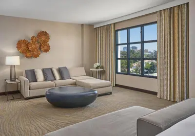a living room with a couch and a large window at Hyatt Regency La Jolla at Aventine in San Diego