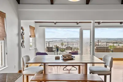 a dining room with a table and chairs and a large window at 26' SUNDECK OCEAN Panoramic VIEWS with AC Fast WiFi -902Mbps in San Diego