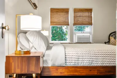a bedroom with a bed with a lamp and two windows at 26' SUNDECK OCEAN Panoramic VIEWS with AC Fast WiFi -902Mbps in San Diego