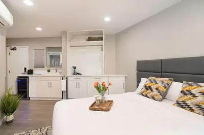 a bedroom with a white bed with a vase of flowers on it at Sands Of La Jolla in San Diego