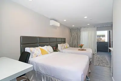 a hotel room with two beds and a desk at Sands Of La Jolla in San Diego