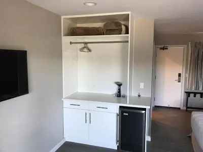 a kitchen with white cabinets and a tv in a room at Sands Of La Jolla in San Diego