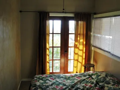 a bedroom with a bed and a window with curtains at RK Hostel in San Diego