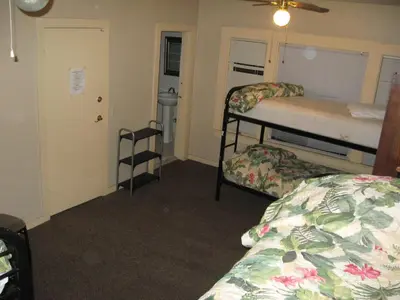 a bedroom with two bunk beds and a door with a window at RK Hostel in San Diego