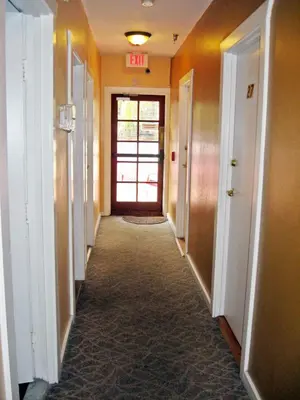 an empty hallway with a exit sign on the wall at RK Hostel in San Diego