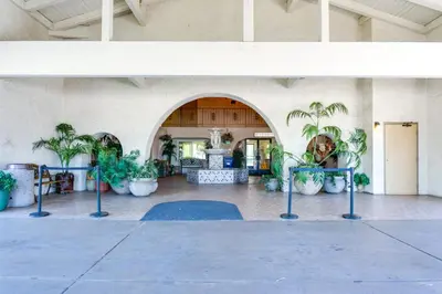a lobby with a bunch of potted plants at California Suites Hotel in San Diego
