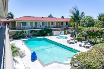 an overhead view of a swimming pool in front of a building at California Suites Hotel in San Diego