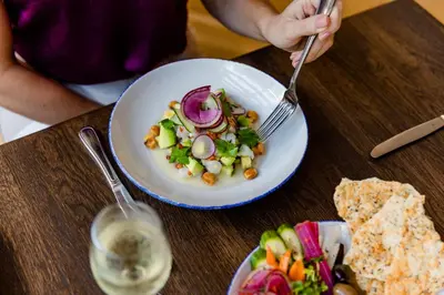 a person holding a fork and a plate of food at Omni San Diego Hotel at the Ballpark in San Diego