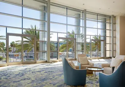 a lobby with large windows and chairs and a table at Omni San Diego Hotel at the Ballpark in San Diego