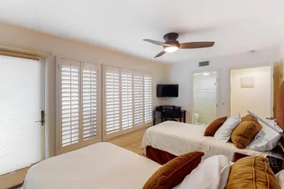 a bedroom with two beds and a ceiling fan at Luxury Oceanfront Home - Lower in Oceanside