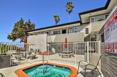 a swimming pool with chairs and a building at San Diego Hub with Bay Views - 1 Block to Beach! in San Diego