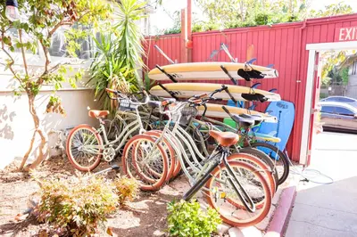 a group of bikes parked next to a building with surfboards at California Dreams Hostel - Ocean Beach in San Diego