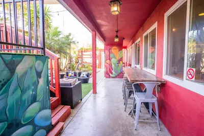 a porch with a table and chairs on a house at California Dreams Hostel - Ocean Beach in San Diego