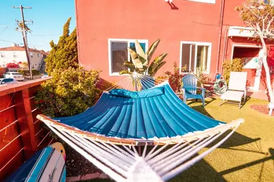 a blue hammock sitting in a yard next to a house at California Dreams Hostel - Ocean Beach in San Diego