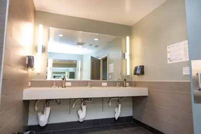 a bathroom with a sink and a large mirror at California Dreams Hostel - Ocean Beach in San Diego