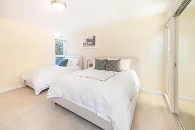 two beds in a bedroom with white walls at Beach Resort Home with Ocean Views Jacuzzi & Sauna! in San Diego
