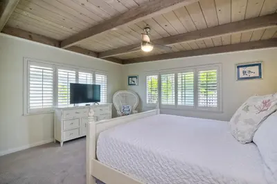 a bedroom with a bed and a flat screen tv at Oceanfront Villa with Private Beach Access, Remodeled Kitchen in Carlsbad