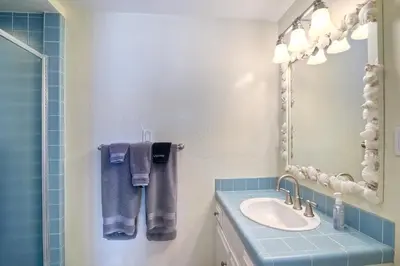 a bathroom with a sink and a mirror and towels at Oceanfront Villa with Private Beach Access, Remodeled Kitchen in Carlsbad