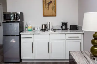 a kitchen with white cabinets and a stainless steel refrigerator at Centrally Located Cozy Studio Apartment in SD in San Diego