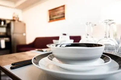 a table with two white bowls and wine glasses at 1-Bedroom with Cali King Size Bed in San Diego in San Diego