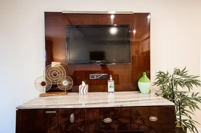 a entertainment center with a flat screen tv and a fan at 1-Bedroom with Cali King Size Bed in San Diego in San Diego