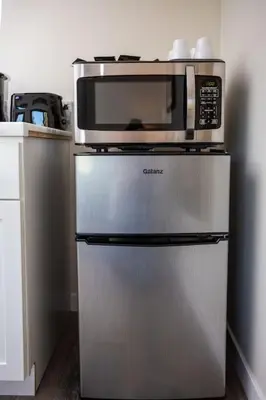 a microwave on top of a refrigerator in a kitchen at Awesome Balboa and Downtown View with Cozy Patio in San Diego