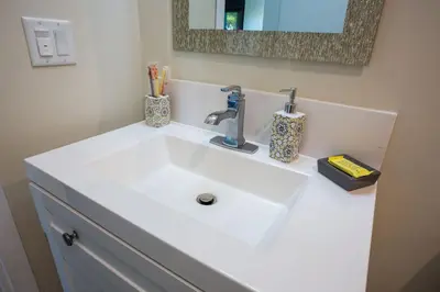 a white bathroom sink with toothbrushes and a mirror at Awesome Balboa and Downtown View with Cozy Patio in San Diego