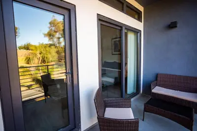 a balcony with two chairs and a glass door at Awesome Balboa and Downtown View with Cozy Patio in San Diego