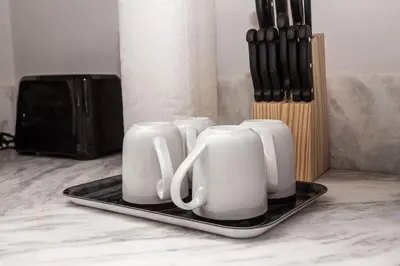 a group of white cups on a tray on a counter at Lovely Studio w Full Kitchen in Heart of San Diego in San Diego